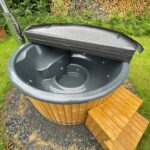 Fiberglass hot tub with integrated wood fired heater